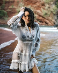 a woman in a white dress standing in the water