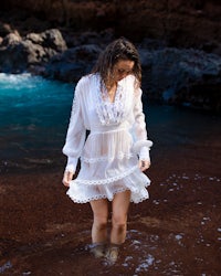 a woman in a white dress standing in the water